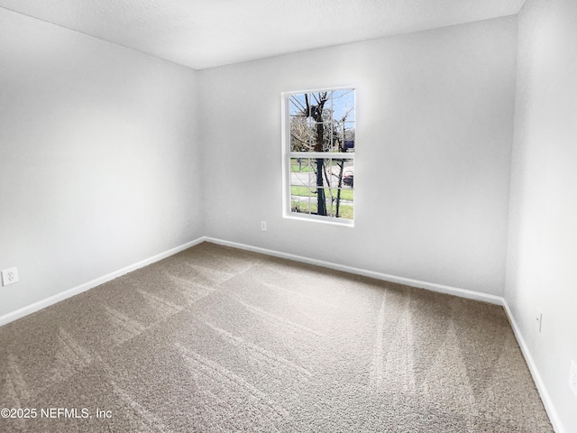 carpeted spare room featuring baseboards and a textured ceiling