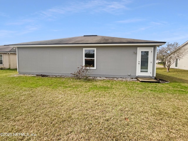 back of property featuring a lawn