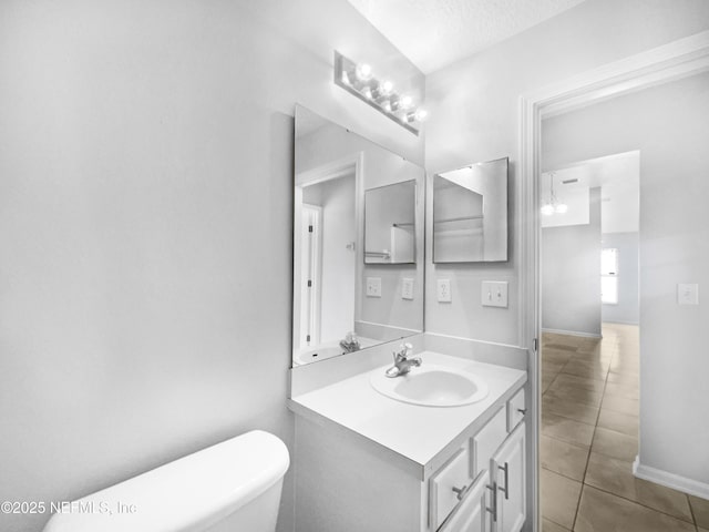 bathroom featuring toilet, tile patterned flooring, a textured ceiling, and vanity