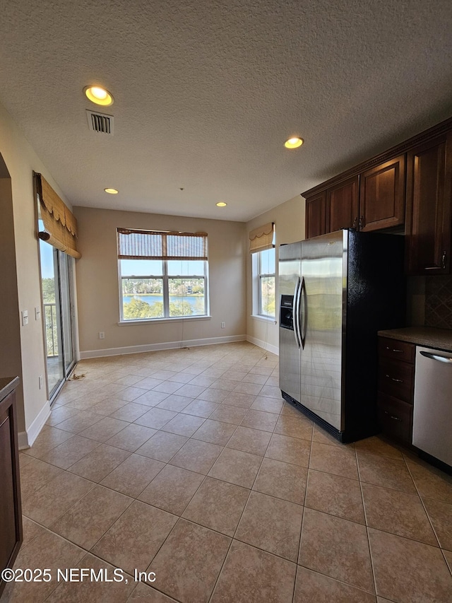 kitchen featuring stainless steel appliances, recessed lighting, visible vents, light tile patterned flooring, and dark brown cabinets