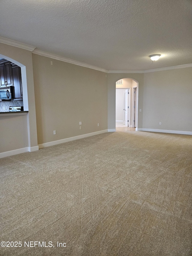 unfurnished room featuring ornamental molding, arched walkways, light carpet, and baseboards