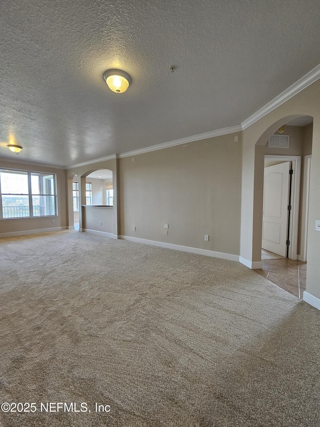 unfurnished living room with arched walkways, carpet floors, visible vents, baseboards, and ornamental molding