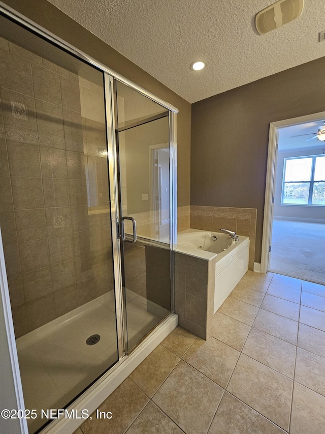 full bath featuring a stall shower, tile patterned flooring, a textured ceiling, and a bath