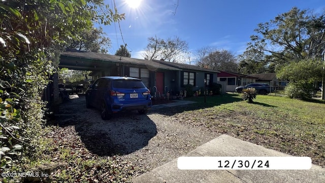 single story home with an attached carport and a front yard