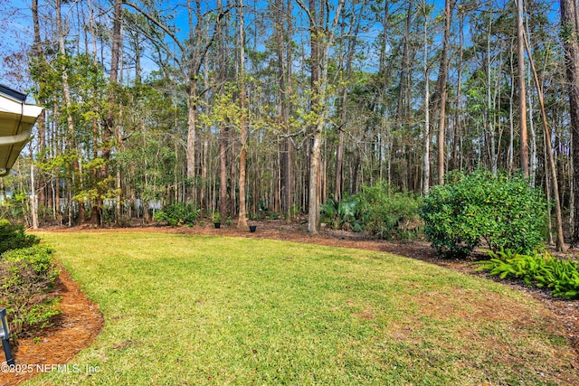 view of yard with a view of trees