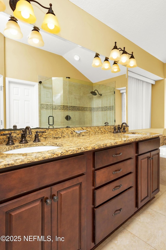 full bath with a stall shower, vaulted ceiling, a sink, and tile patterned floors