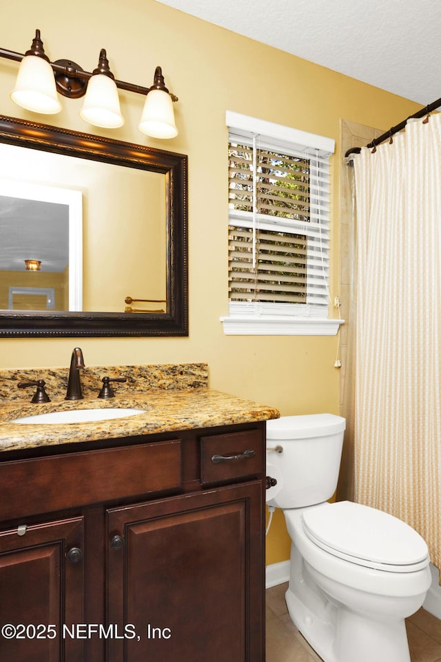 full bath featuring tile patterned flooring, vanity, toilet, and a textured ceiling