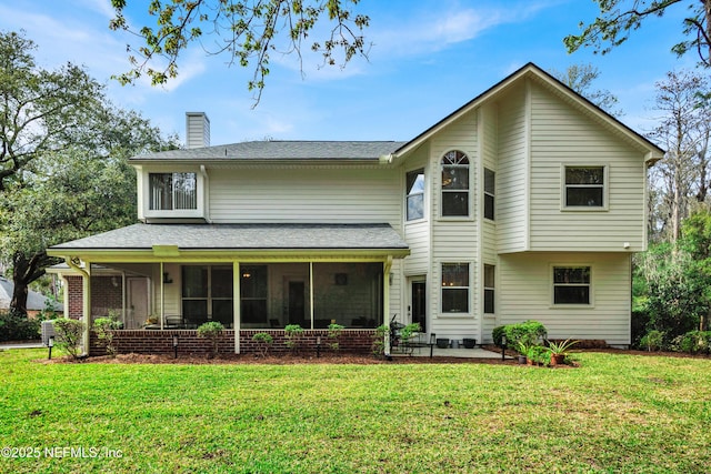 view of front facade featuring a patio, a front lawn, a chimney, and a sunroom