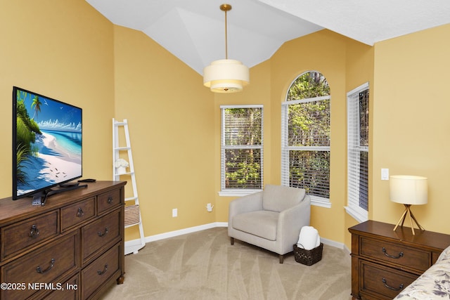 sitting room with light carpet, vaulted ceiling, and baseboards