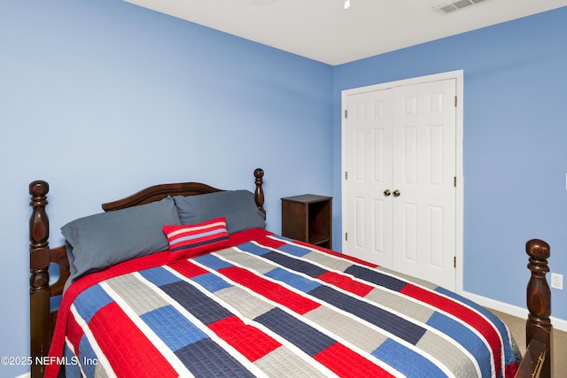 carpeted bedroom with a closet, visible vents, and baseboards