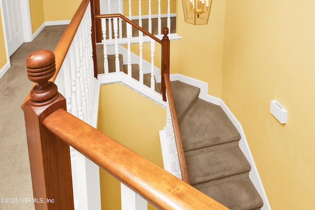 stairs with carpet, baseboards, and a notable chandelier