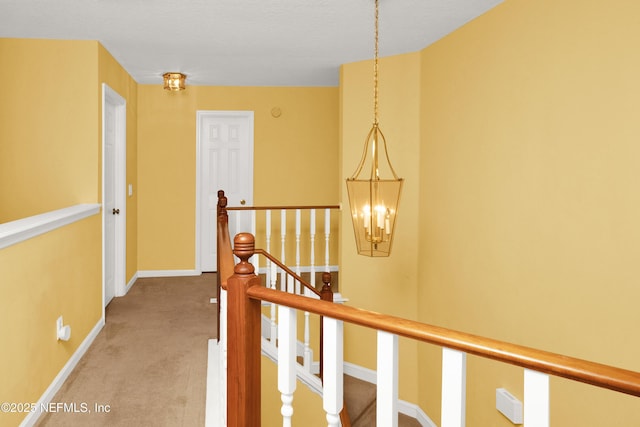 corridor with light carpet, an upstairs landing, and baseboards