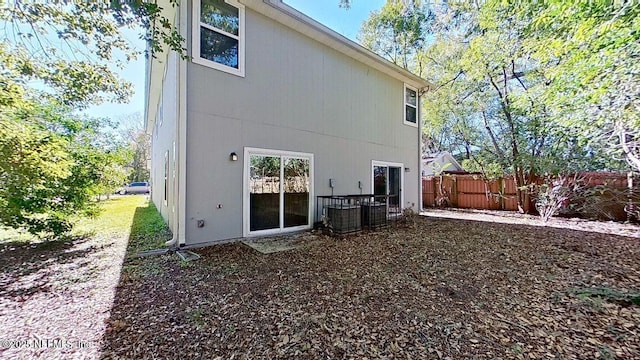 back of property with central AC and fence