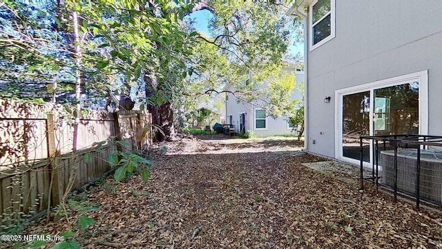 view of yard with fence and central air condition unit