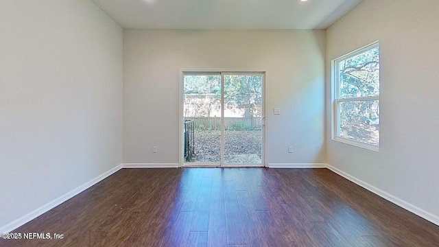 spare room with dark wood-style floors and baseboards