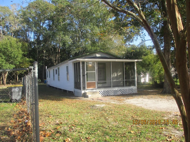 view of front facade featuring a sunroom and a front lawn