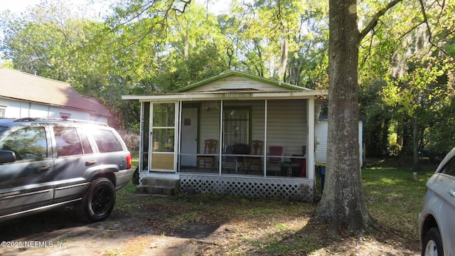 view of front of property featuring washer / clothes dryer, entry steps, and a sunroom