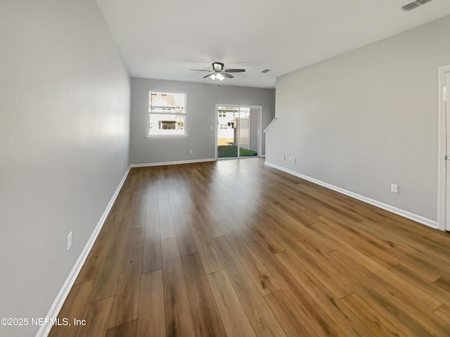 unfurnished living room featuring wood finished floors, a ceiling fan, and baseboards