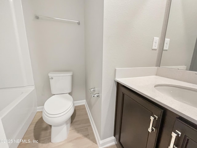 full bath with toilet, vanity, and baseboards