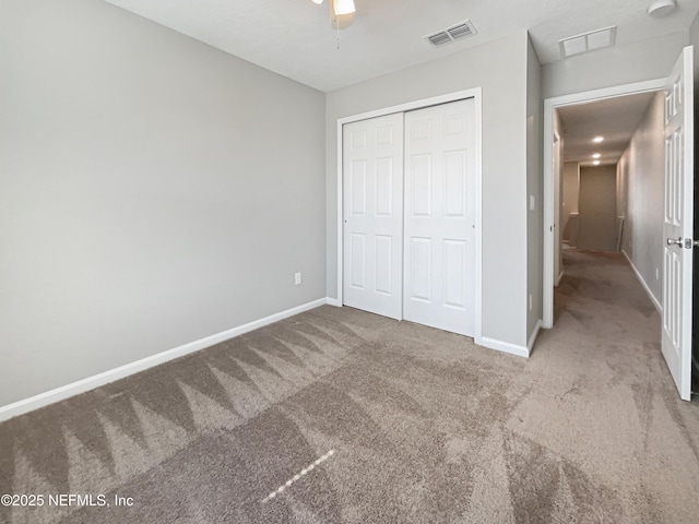 unfurnished bedroom with a closet, visible vents, baseboards, and carpet flooring