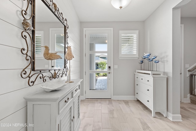 foyer entrance featuring light wood finished floors and baseboards