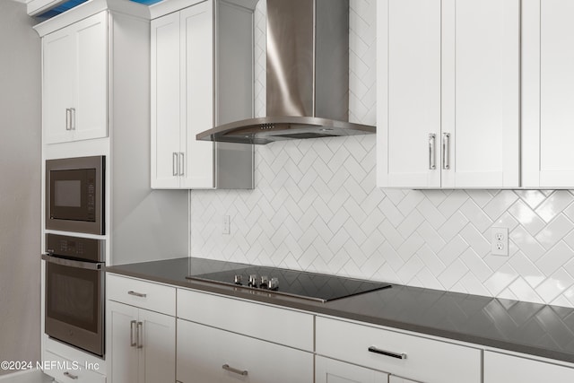 kitchen featuring dark countertops, wall chimney range hood, stainless steel oven, and built in microwave