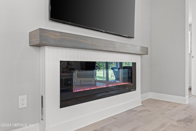 details featuring a glass covered fireplace and baseboards