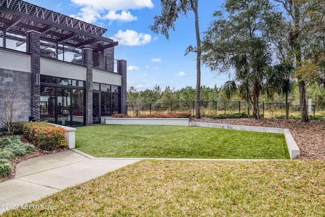 view of property's community featuring a yard and fence