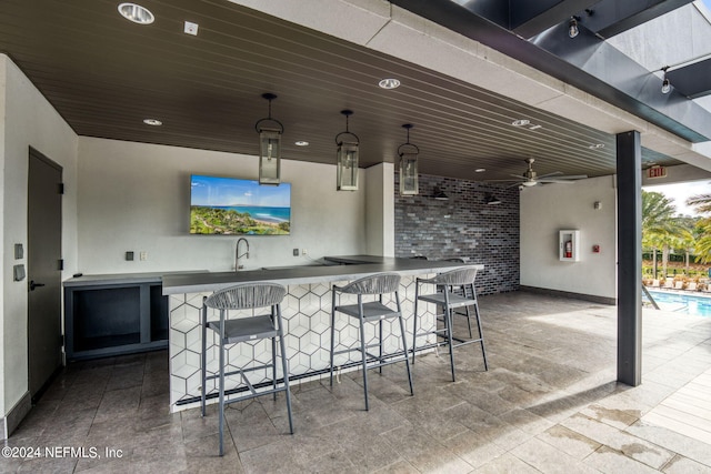 view of patio / terrace with ceiling fan, an outdoor pool, a sink, and outdoor wet bar