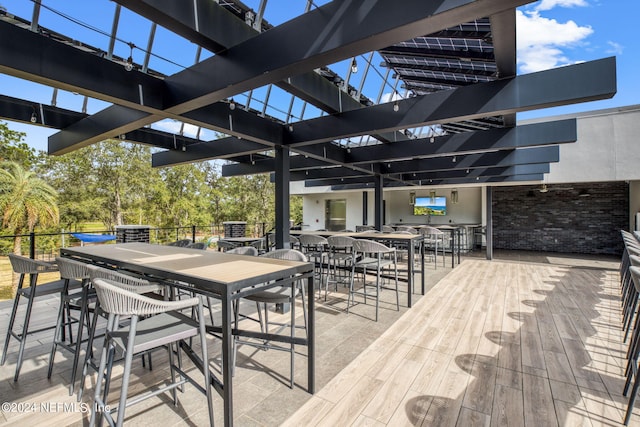 deck featuring outdoor dining area and a pergola