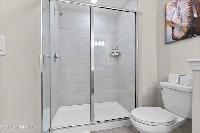 full bathroom featuring toilet and a shower stall