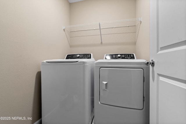 laundry room featuring separate washer and dryer and laundry area