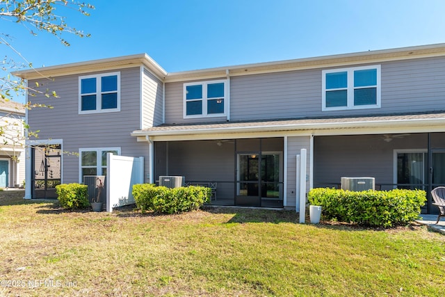 back of house featuring a lawn, central AC unit, and a sunroom