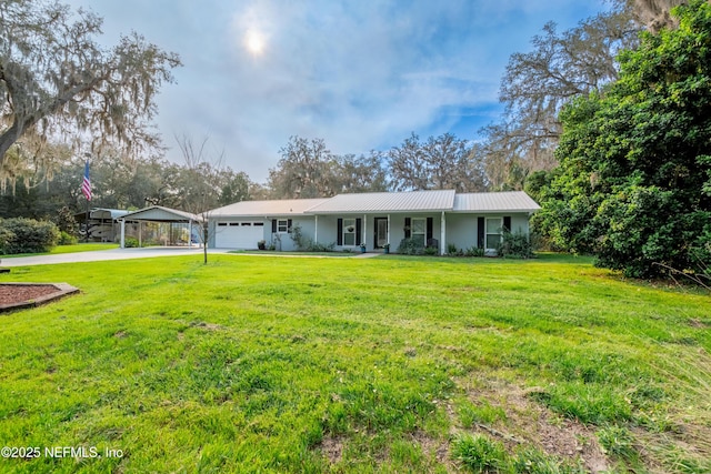 view of front of property with metal roof, driveway, a porch, and a front yard