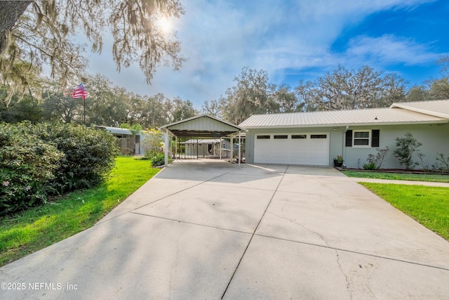 ranch-style home with stucco siding, an attached garage, a front yard, metal roof, and driveway