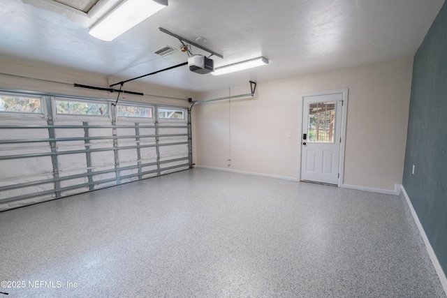 garage with baseboards, visible vents, and a garage door opener