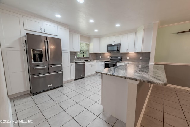 kitchen featuring stone countertops, a peninsula, stainless steel appliances, white cabinetry, and light tile patterned flooring