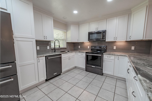 kitchen featuring light tile patterned flooring, a sink, white cabinetry, appliances with stainless steel finishes, and backsplash