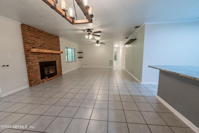 unfurnished living room with visible vents, baseboards, ceiling fan, ornamental molding, and light tile patterned flooring