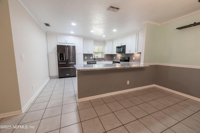 kitchen with tasteful backsplash, visible vents, white cabinets, a peninsula, and stainless steel appliances