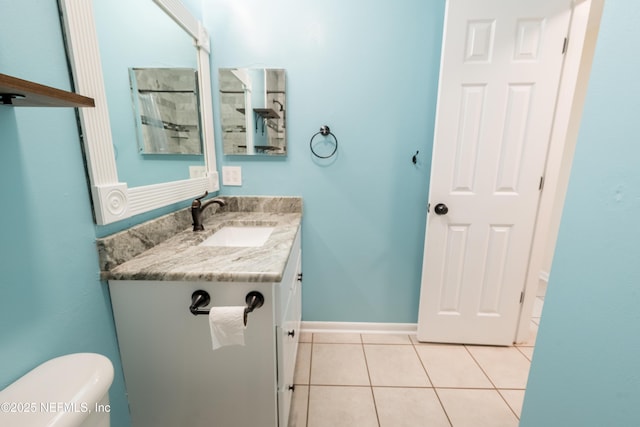 bathroom featuring toilet, tile patterned flooring, baseboards, and vanity