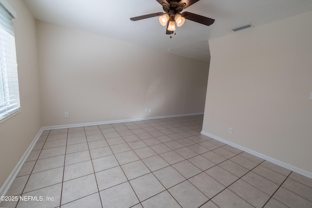 empty room featuring ceiling fan, visible vents, and baseboards