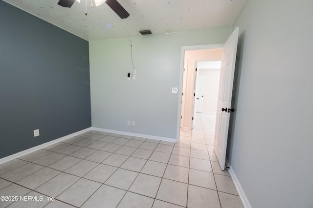 unfurnished room with light tile patterned floors, ceiling fan, visible vents, and baseboards