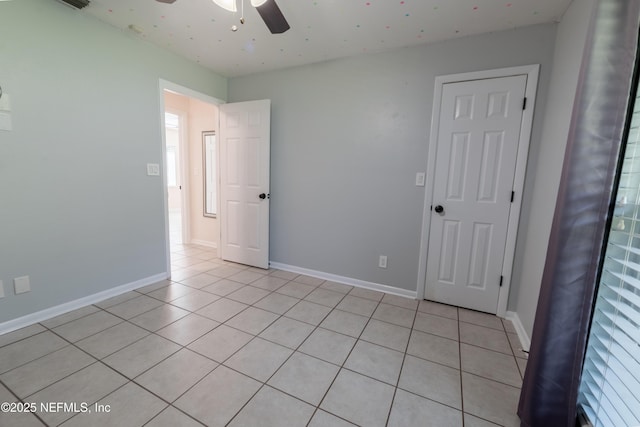 unfurnished bedroom with ceiling fan, baseboards, and light tile patterned floors