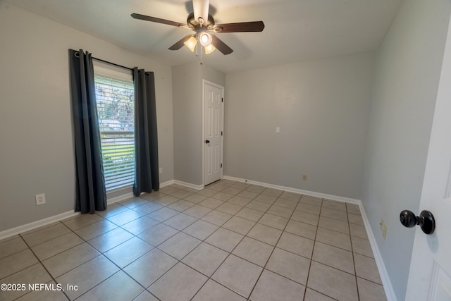 spare room with ceiling fan, light tile patterned floors, and baseboards