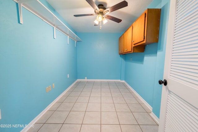 washroom featuring cabinet space, ceiling fan, baseboards, and light tile patterned flooring