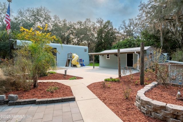 view of yard with driveway and a patio