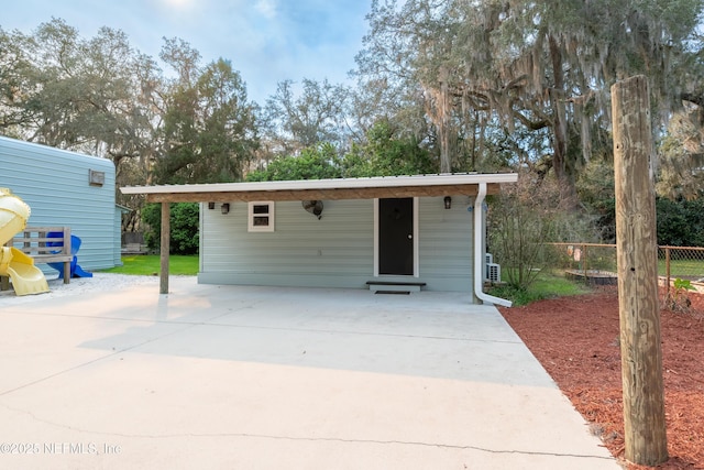 view of outbuilding featuring driveway and fence