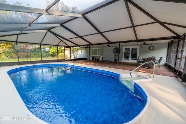 outdoor pool with a patio area, glass enclosure, and a ceiling fan