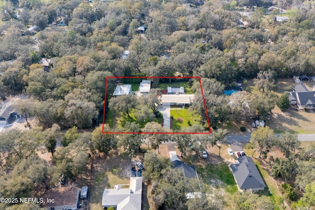 birds eye view of property with a view of trees